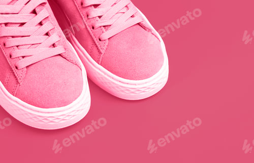 Preview: Female sneakers fashion trend color 2023 Viva Magenta close-up, copy space.