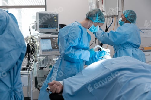 Preview: Caucasian female surgeon wearing face mask putting oxygen mask on patient lying in bed