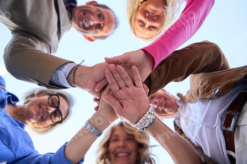 Preview: Senior friends joining hands showing teamwork and unity