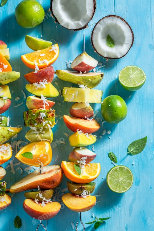 Preview: Colorful Fruit Skewers with Coconut on Blue Background
