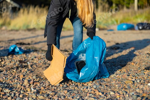 Preview: Close-up up of volunteer woman picking up garbage at beach