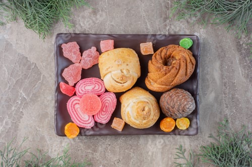 Preview: Vanilla powder coated almond wraps and marmelade on a next to pine leaves on marble background