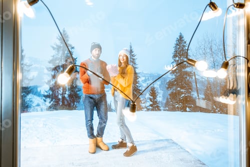 Preview: Couple on the terrace of the house in the snowy mountains