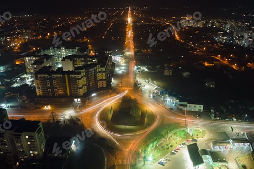 Preview: Aerial view of high rise apartment buildings and bright illuminated roundabout intersection on urban