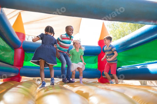 Preview: Friends playing on bouncy castle at playground