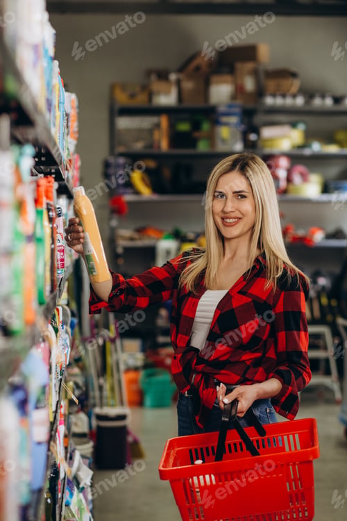 Preview: Woman choosing laundry detergent in grocery store.