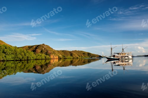 Preview: Peaceful Ocean Scenery with a Boat and Green Hills