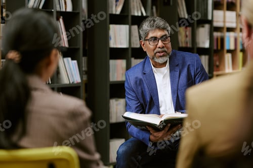 Preview: Middle Aged South Asian Man Leading Book Presentation in Library Setting