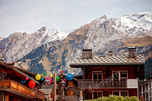 Preview: Alpine village, autumn meets early winter, golden leaves against snow peaks. Travel, peaceful calm