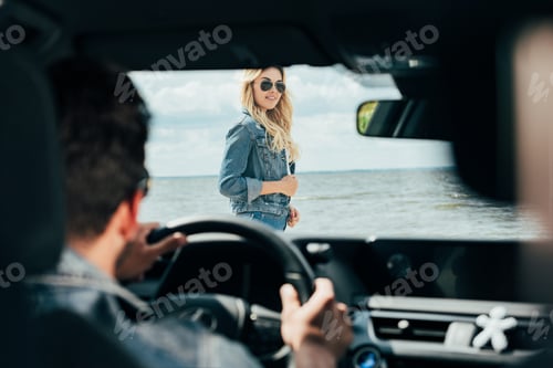 Preview: selective focus of attractive woman in denim jacket looking at man