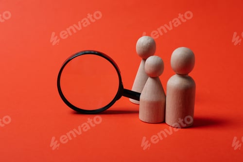 Preview: Magnifying glass and wooden figures on red background