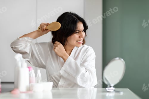 Preview: Woman Brushing Tangled Hair in Bedroom