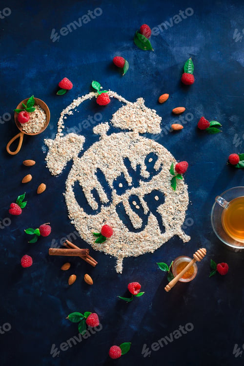 Preview: Alarm clock with Wake Up words written with oatmeal, raspberries and cinnamon. Healthy eating