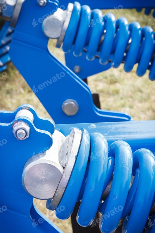 Preview: Hard blue spring made of steel. Part of big industrial or agricultural machine