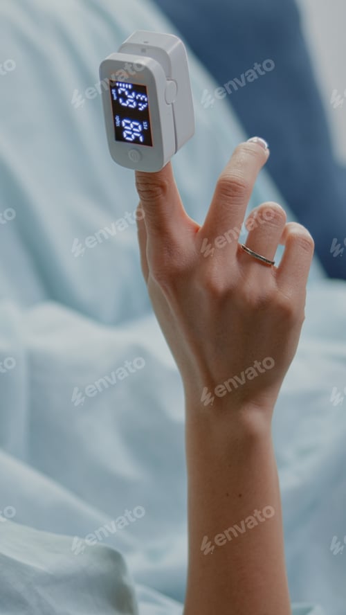 Preview: Close up of unwell woman holding oximeter on finger