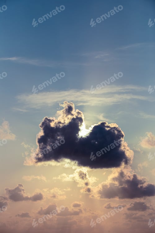 Preview: A large cloud is in the sky above the ocean. The sun is setting, casting a warm glow over the water