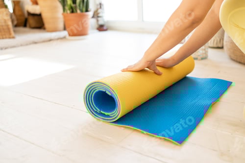 Preview: Adult Unrolling a Colorful Yoga Mat at Home