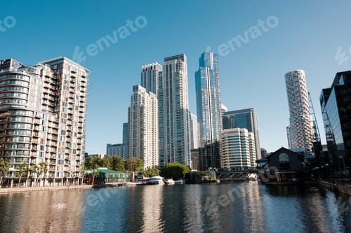 Preview: Modern skyscrapers reflecting on millwall inner dock water in london, during a sunny day