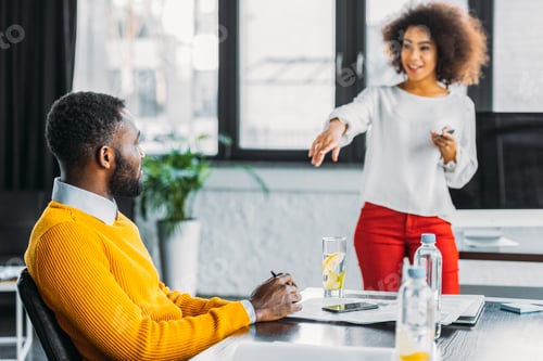 Preview: african american businesswoman pointing on colleague in office
