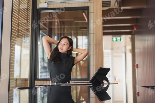 Preview: Young woman relaxing stretching in modern office space