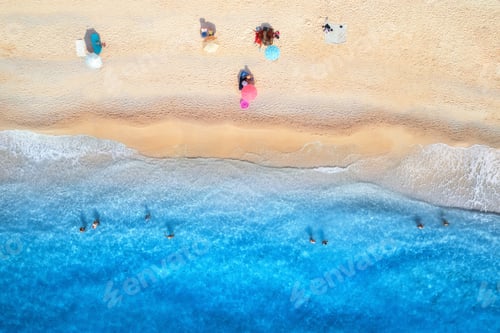 Visualização: Vista aérea do mar azul, praia arenosa, guarda-sóis, pessoas nadadoras