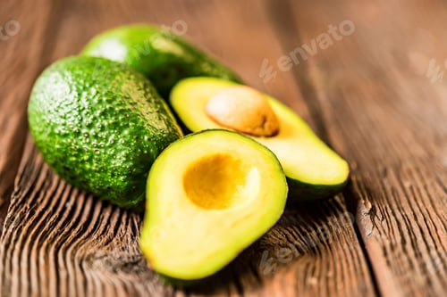 Preview: Avocados cut and whole on a wooden background