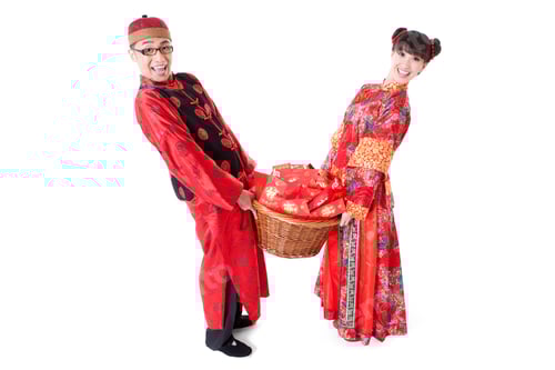 Preview: Happy young couple in Tang suit holding a basket of red pockets
