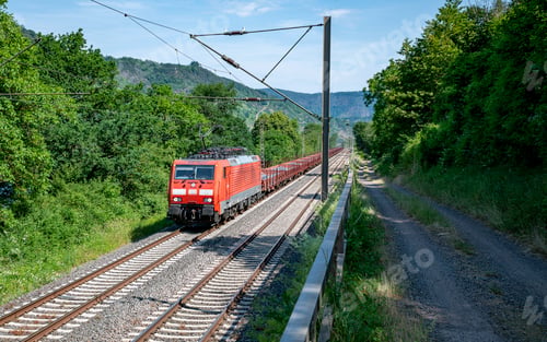 Preview: a train of the Deutsche Bundesbahn drives through the German green landscape