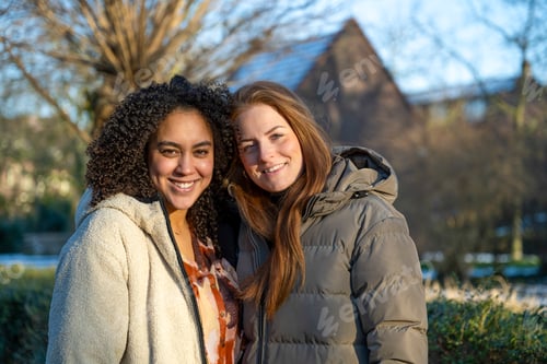 Preview: Two friends sharing a joyful moment outdoors with a beautiful sunset light.