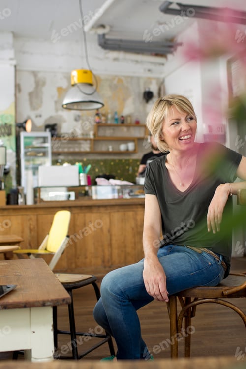 Preview: Mid adult woman sitting in cafe