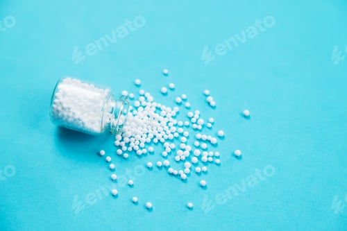 Preview: Homeopathic glass bottle on a blue background. Alternative herbs medicine homeopathy.