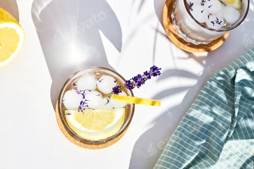 Preview: Top view of a glass of refreshing cocktail with lemon slices and fresh lavender flowers.Summer drink