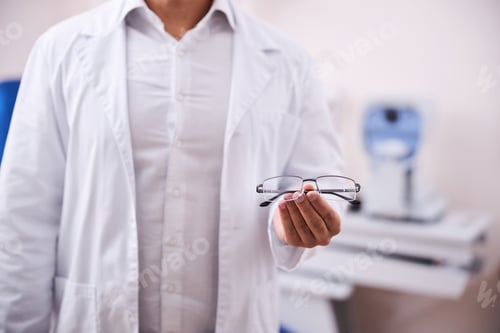 Preview: Eyewear consultant in a lab coat offering trendy spectacles