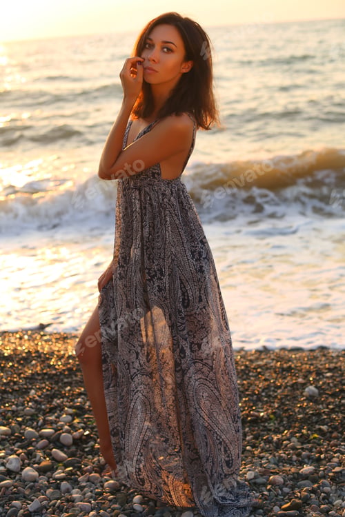 Preview: Fashion Outdoor Photo Of Beautiful Woman With Dark Hair In Elegant Dress Posing On Sunset Beach