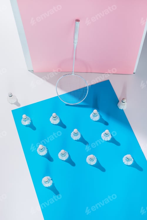 Preview: top view of badminton racket and shuttlecocks on blue and pink papers
