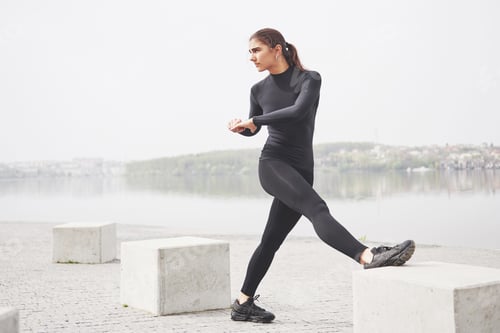 Preview: A young woman is engaged in sports on the shore of a lake in the park