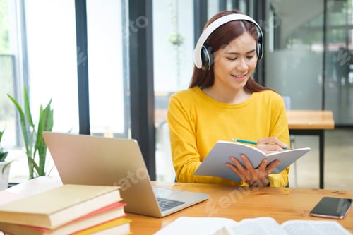 Preview: Woman learning online using laptop and writing notes.