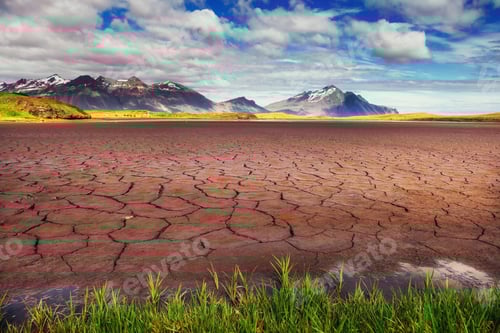 Preview: Cracked Earth Landscape with Mountains and Cloudy Sky