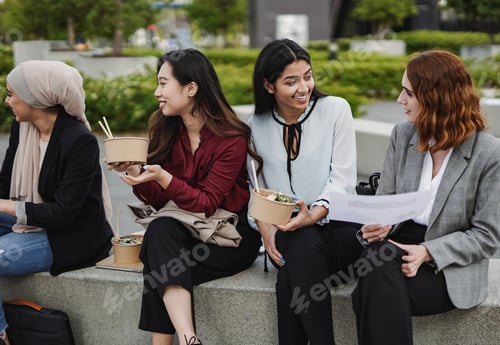Preview: Multiracial business women eating together outside of office