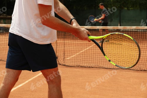 Preview: Two men playing tennis on clay court