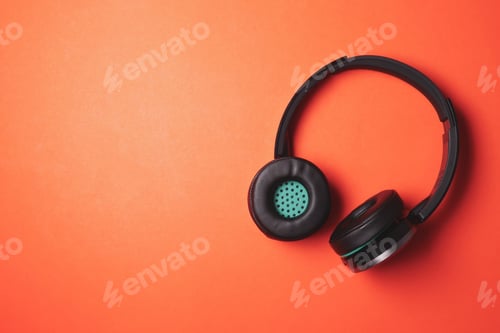 Preview: Modern headphones on a orange background. Free space for text