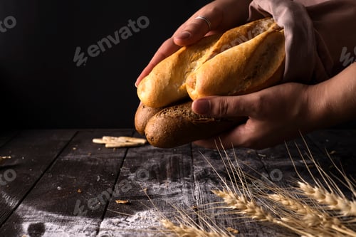 Preview: Baker woman holding rustic organic loaf of bread in hands - rural baker