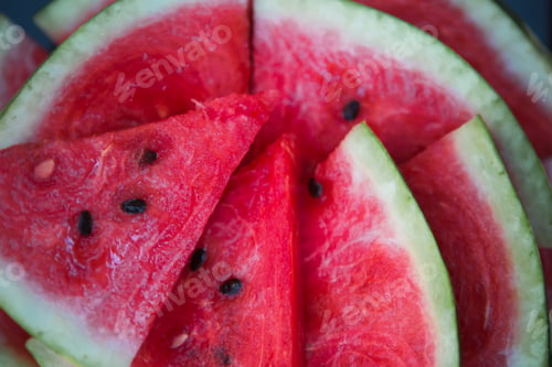 Preview: Juicy bright red pieces of sliced watermelon on a black table background.