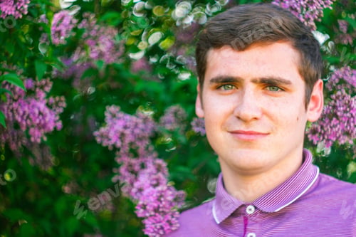 Preview: Defocus smiling caucasian man outdoors portrait. Spring people. Young men in purple shirt on nature
