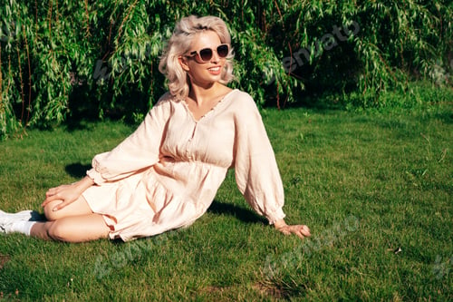 Preview: Young beautiful smiling blond woman posing outdoors