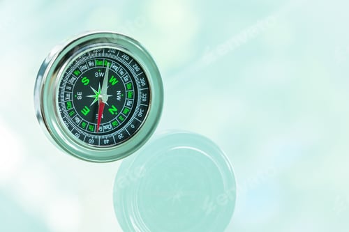 Preview: Exploring direction with a compass on a clear surface near trees