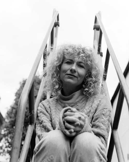 Preview: Film portrait of woman sitting on slide ladder outdoors.