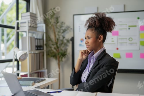 Preview: Young businesswoman is thinking with a concerned expression while working at her desk in an office