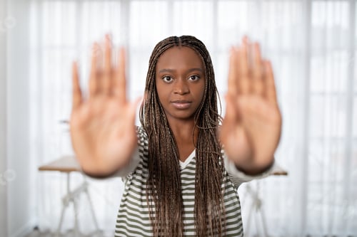 Preview: Concerned young african american woman showing stop gesture
