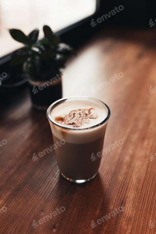 Preview: Cup of coffee at table in cafe near window. Blurred background